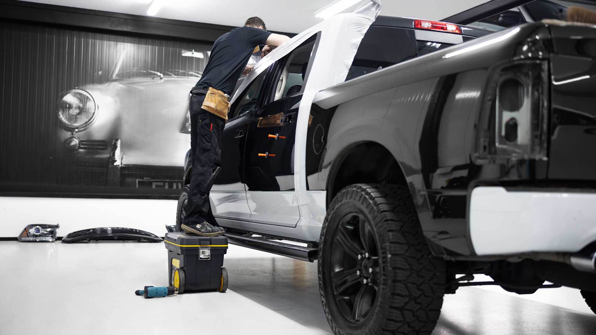 Certified installer applying protection tape before vehicle wrap in Buena Park