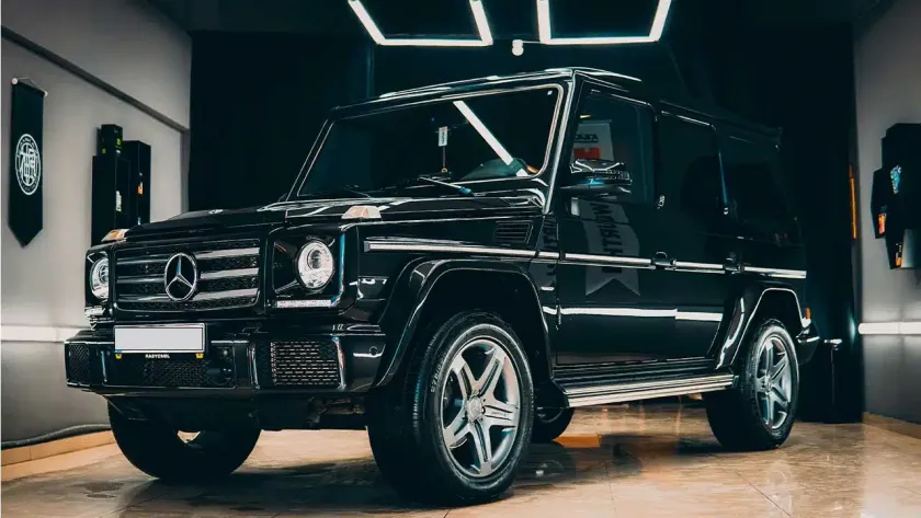 Black Mercedes G-Wagon parked inside a shop with professional window tint applied.