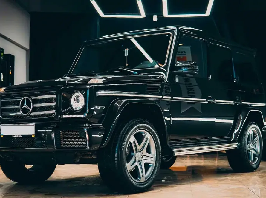 Black Mercedes G-Wagon parked inside a shop with professional window tint applied.